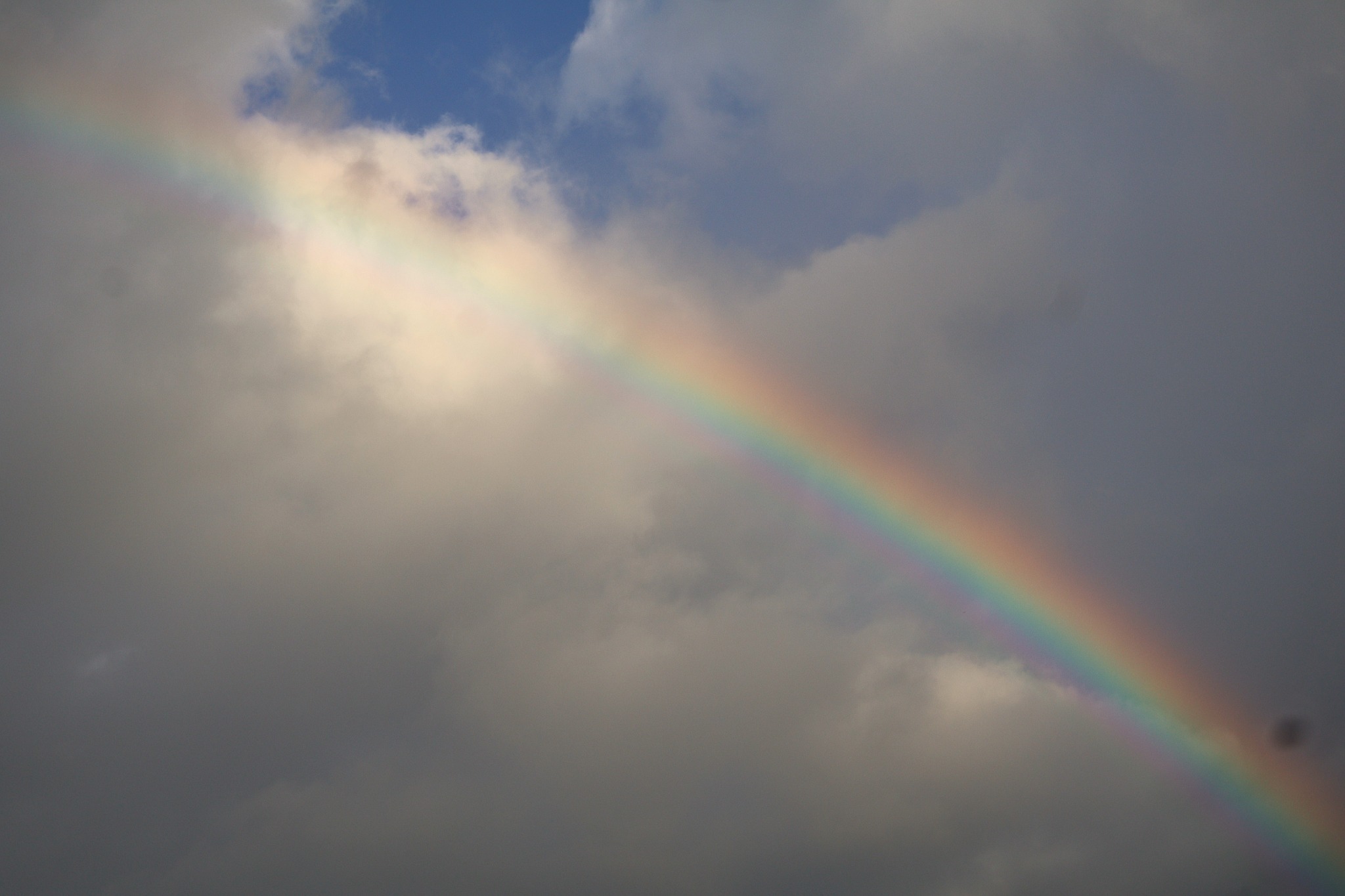 Rainbow crossing a cloudy sky